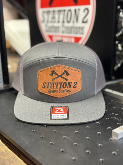 Heather grey Richardson 168 seven-panel hat with engraved rawhide crossed-axes patch