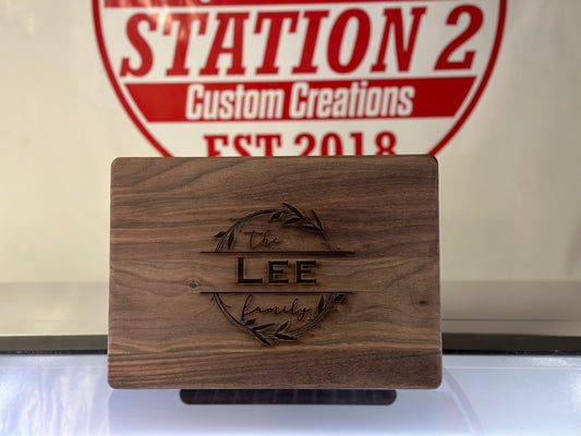 Walnut cutting board laser engraved with a custom logo, displayed in the shop