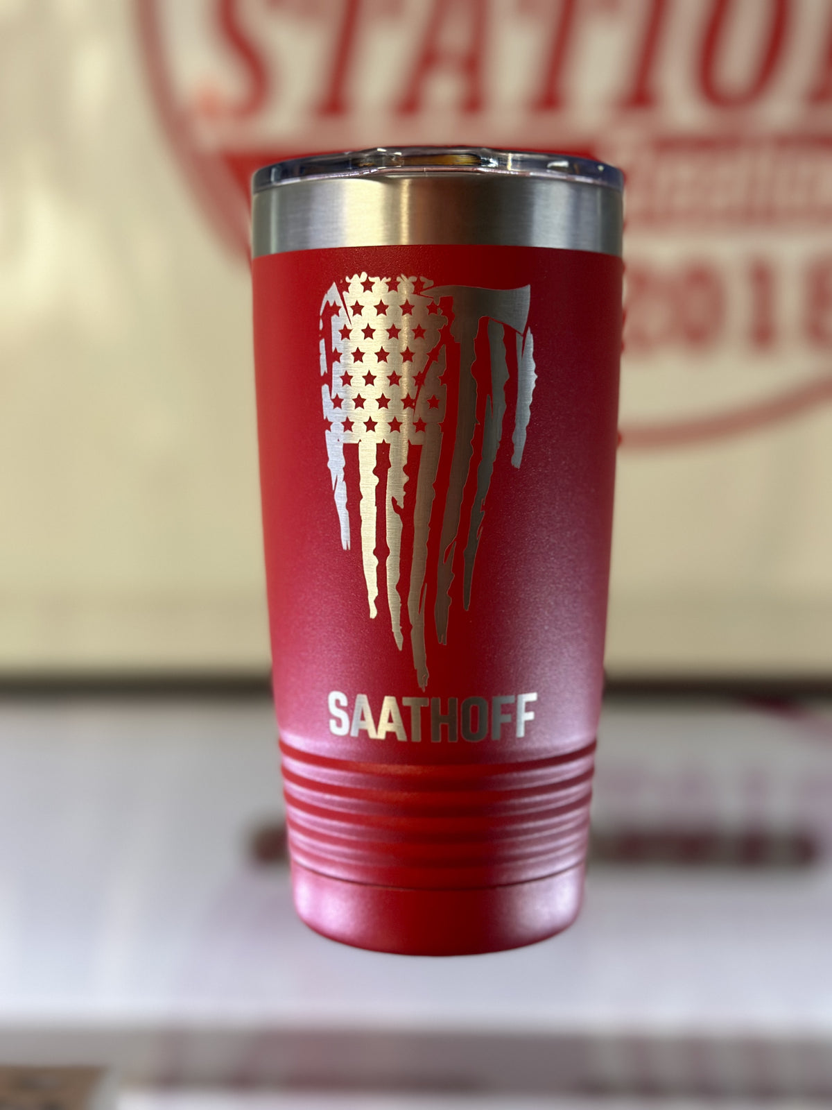 Red firefighter tumbler engraved with a distressed flag, axe and custom name