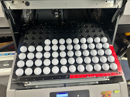 Golf ball jig for the Mimaki UJF-6042 loaded with golf balls in the printer bed